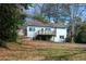 Exterior rear view of the light blue home with a deck, staircase, fenced yard, and mature trees at 5087 Fairmont Se Rd, Smyrna, GA 30082
