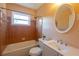 This bathroom has tile walls surrounding the bathtub, a sleek vanity and a framed round mirror at 5087 Fairmont Se Rd, Smyrna, GA 30082