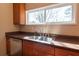 Well-lit kitchen featuring a double stainless steel sink under a window at 5087 Fairmont Se Rd, Smyrna, GA 30082