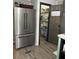 Modern kitchen with a stainless steel refrigerator and a rustic barn door leading to a pantry at 91 East Meadow Ln, Conyers, GA 30012