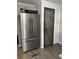 Modern kitchen with a stainless steel refrigerator and a rustic barn door leading to a pantry at 91 East Meadow Ln, Conyers, GA 30012