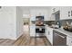 Modern kitchen with stainless steel appliances, white cabinets, gray backsplash, and wood flooring at 1069 Falling Water Se Dr, Smyrna, GA 30080