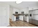 Modern kitchen featuring stainless steel appliances, white cabinets, gray backsplash, and wood flooring at 1069 Falling Water Se Dr, Smyrna, GA 30080
