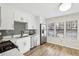 Sunlit modern kitchen with stainless appliances, white cabinets, grey backsplash, and wood flooring at 1069 Falling Water Se Dr, Smyrna, GA 30080