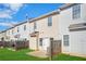 A view of the townhome's backyard including the fence, small patio and door to the home on a bright day at 2502 Capella Sw Cir, Atlanta, GA 30331