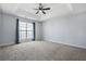 Spacious bedroom features a tray ceiling with ceiling fan and a large window with blinds and curtains at 2502 Capella Sw Cir, Atlanta, GA 30331