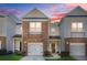 Attractive townhome boasting a stone-accented facade, single-car garage, and a welcoming entrance under a soft sky at 2502 Capella Sw Cir, Atlanta, GA 30331