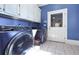 Modern laundry room with front-load washer/dryer and sleek blue cabinets at 3440 Caleb Rd, Snellville, GA 30039