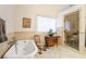 Bathroom featuring a tub and glass shower, with neutral colors and a bright window at 415 S Woodland Sw Dr, Marietta, GA 30064