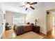 Bedroom features hardwood floors, ceiling fan, neutral color palette, and a large window for natural light at 415 S Woodland Sw Dr, Marietta, GA 30064