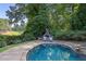 Beautiful backyard pool with stone edging and a tranquil view of the golf course beyond the trees at 415 S Woodland Sw Dr, Marietta, GA 30064