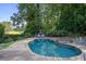 Inviting backyard pool and patio area nestled in a lush, green landscape, ideal for relaxation and recreation at 415 S Woodland Sw Dr, Marietta, GA 30064