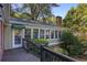 Sunroom with a wall of windows, accessed from a wooden deck, and surrounded by greenery at 415 S Woodland Sw Dr, Marietta, GA 30064