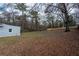 Large backyard with a shed, mature trees, a wood fence, and seasonal foliage at 4985 Union St, Union City, GA 30291