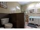 Bathroom featuring a toilet, vanity with a glass bowl sink, tiled walls, and neutral paint at 4985 Union St, Union City, GA 30291