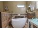 Bright bathroom with a free-standing tub, tiled walls, vanity with a glass bowl sink, and artwork at 4985 Union St, Union City, GA 30291