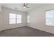 Spacious bedroom with neutral carpet, ceiling fan, and multiple windows for natural light at 6945 Merrywood Dr, Fairburn, GA 30213