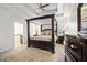 Luxurious main bedroom featuring a four-poster bed, tray ceiling, and adjoining bathroom at 6945 Merrywood Dr, Fairburn, GA 30213