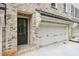 Charming townhome displaying the garage and entry door, both accented by decorative iron hardware at 1041 Endeavour Ct, Marietta, GA 30064