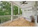 Relaxing porch with wood floors overlooking mature trees, ceiling fan, and railing at 1041 Endeavour Ct, Marietta, GA 30064