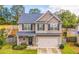 Charming two-story home features a welcoming front porch, neat landscaping, and a two-car garage at 307 Morning Frost, Canton, GA 30114