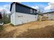 Backyard view of the home showcasing a newly renovated white brick exterior and a dark siding addition at 3565 Collier Drive Nw Rd, Atlanta, GA 30331