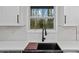 Close-up of a modern kitchen sink with a black faucet and white countertops, set against a backdrop of natural light at 3565 Collier Drive Nw Rd, Atlanta, GA 30331