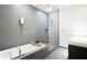 Sleek bathroom with soaking tub, glass shower, gray tile and modern fixtures at 45 Ivan Allen Jr Nw Blvd # 1908, Atlanta, GA 30308