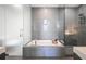 Modern bathroom featuring a soaking tub, glass-enclosed shower, and stylish gray tile at 45 Ivan Allen Jr Nw Blvd # 1908, Atlanta, GA 30308