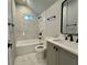 A full bathroom with white marble tile, dark fixtures, and a shower over tub at 958 Joseph E Boone Nw Blvd, Atlanta, GA 30314