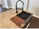 Close up of a kitchen island with a granite countertop, farmhouse sink and black faucet at 958 Joseph E Boone Nw Blvd, Atlanta, GA 30314