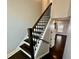 Staircase with dark hardwood treads, white risers, and a modern wood and black railing at 958 Joseph E Boone Nw Blvd, Atlanta, GA 30314