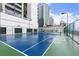 Bright blue tennis court surrounded by tall buildings and a high fence at 1280 W Peachtree Nw St # 3303, Atlanta, GA 30309