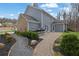 Beautiful home featuring an outdoor kitchen with an expansive brick patio surrounded by lush greenery and landscaping at 1366 Kings Park Nw Dr, Kennesaw, GA 30152