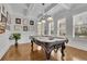 Bright game room featuring coffered ceilings, hardwood floors, and an ornate pool table with unique light fixture at 1366 Kings Park Nw Dr, Kennesaw, GA 30152