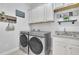 Well-organized laundry room with granite countertops and modern washer and dryer at 1366 Kings Park Nw Dr, Kennesaw, GA 30152