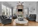 Comfortable living room features plush seating, a stone fireplace, and large windows with plantation shutters at 1366 Kings Park Nw Dr, Kennesaw, GA 30152