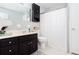 Bright bathroom with dark vanity, black medicine cabinet and shower/tub combo at 1650 Seayes Sw Rd, Mableton, GA 30126