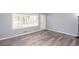 Bright living room with large window, light gray walls, and stylish modern gray and brown flooring at 1650 Seayes Sw Rd, Mableton, GA 30126