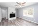 Open floor plan featuring a ceiling fan, wood grain floors, brick fireplace and light gray walls at 1650 Seayes Sw Rd, Mableton, GA 30126