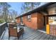 View of the brick back exterior and back deck features seating and black railing at 2140 Meador Se Ave, Atlanta, GA 30315