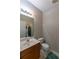 Clean powder room featuring a pedestal sink, toilet, and neutral wall color with laundry in the back at 2021 Austin Park Cir, Decatur, GA 30032