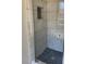 Modern shower with black pebble flooring and marble-style tiling at 2250 Camp Town Way, Lawrenceville, GA 30044