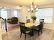 Well lit dining room showcasing chandelier lighting with staircase access to the left and living area access to the right at 235 Windcroft Nw Ln, Acworth, GA 30101