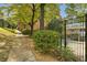 Landscaped walkway to community pool bordered by a wrought iron fence and mature trees at 2551 Bradford Ne Sq, Atlanta, GA 30345