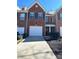 Charming brick townhome featuring a one car garage and driveway at 3148 Glenloch Pl, Lawrenceville, GA 30044