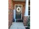 Cozy front porch entrance, with brick columns and festive wreath and decorations at 3148 Glenloch Pl, Lawrenceville, GA 30044