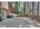 Concrete backyard patio area with basketball hoop and tree-lined border at 775 Hales Trace Sw Way, Lilburn, GA 30047