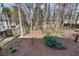 View of the backyard with mature trees and a mulched area at 775 Hales Trace Sw Way, Lilburn, GA 30047