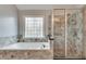 Bathroom with large soaking tub and glass enclosed shower with patterned window at 775 Hales Trace Sw Way, Lilburn, GA 30047
